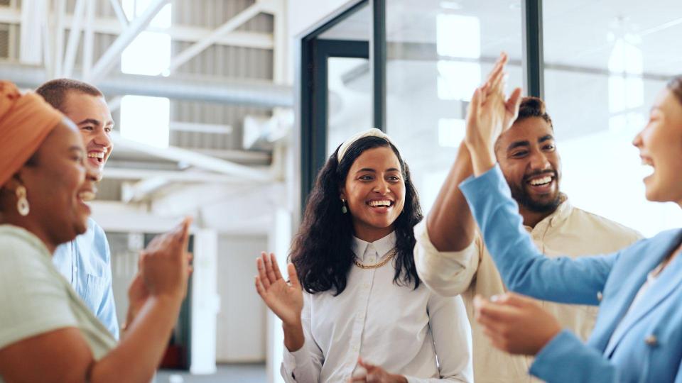 Five members of a B2B sales team celebrate closing a deal with an enterprise account