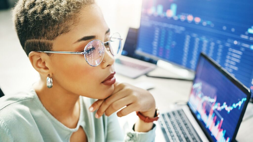 Woman looking thoughtfully at laptop screen