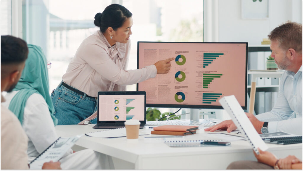 A revenue team looks at graphs together on a screen