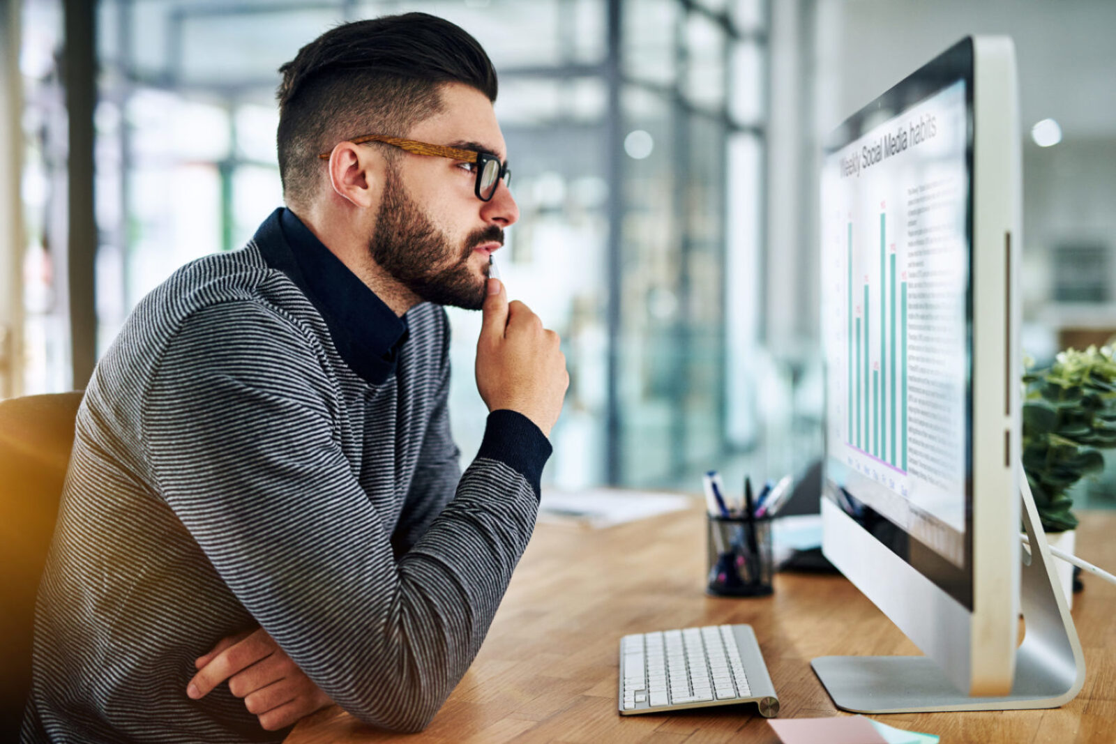 Shot of a young designer looking thoughtful while working on a computer in an office.