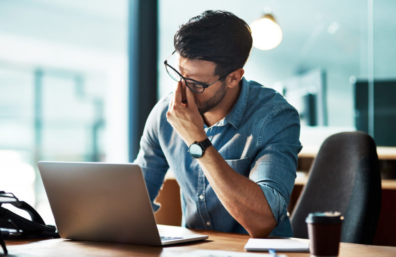 Stressed, tired and frustrated business man with headache at night from burnout or making mistake on laptop. Overworked creative entrepreneur failing to meet late office deadline or working overtime.